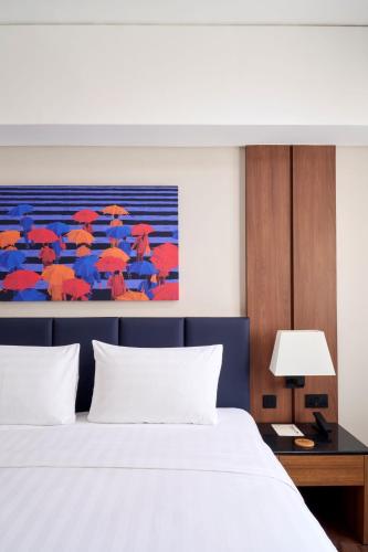 a bedroom with a bed and a painting of umbrellas at Seda Centrio Newly Renovated in Cagayan de Oro