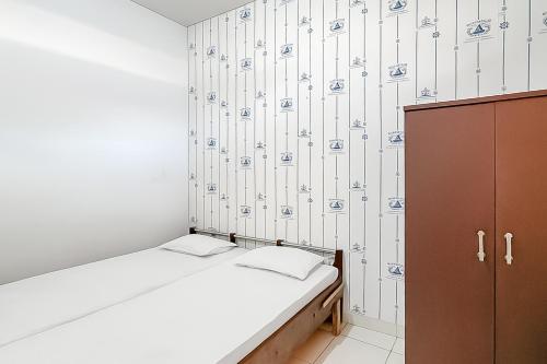 a small room with a bed and a cabinet at Villa Anugerah Linggarjati Mitra RedDoorz in Sangkanurip