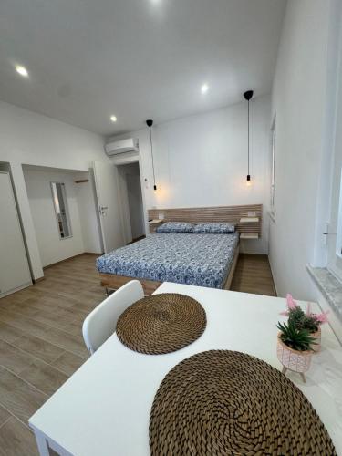 a room with two beds and a table and chairs at Casette in centro Por Siempre Cuatro House in Ischia