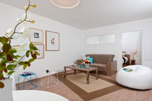a living room with a couch and a table at Ténéo Apparthotel Talence - Arthena in Talence