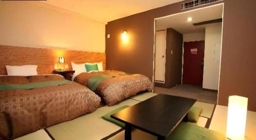 a hotel room with two beds and a mirror at Hotel 1-2-3 Kofu Shingen Onsen in Kofu