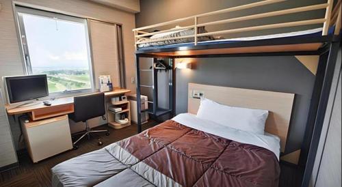 a bedroom with a bunk bed and a desk with a computer at Super Hotel Arai-Niigata in Myoko