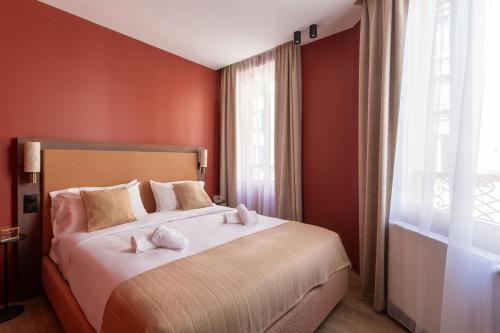 a bedroom with a large bed with red walls at Sol hotel St Mande - 4 personnes - 11 in Saint-Mandé