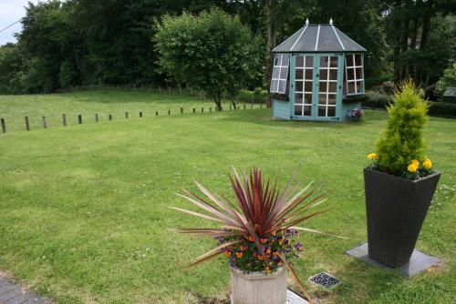 a garden with a gazebo and a plant in a yard at Ayrs and Graces - Luxury Bed and Breakfast in Ayr