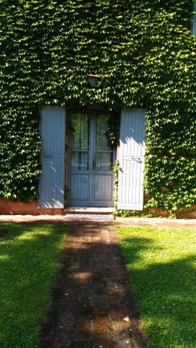 a building with two blue doors and green ivy at Alloggio Al San Girolamo in Longiano