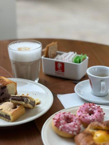 a table with plates of pastries and a cup of coffee at Il Grifo Hotel e Bisteccheria Toscana in Montepulciano