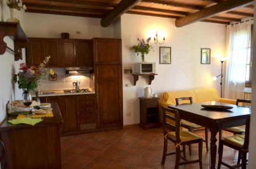eine Küche und ein Wohnzimmer mit einem Tisch, einer Küche und einem Esszimmer in der Unterkunft Agriturismo Il Casalone in Montepulciano