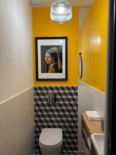 a bathroom with a picture of a woman on the wall at L'Escapade d'Acquigny, Piscine, Foot Five, Salle de sport, BabyFoot in Acquigny