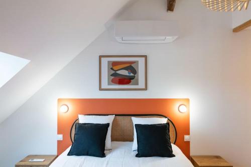 a bedroom with a bed with an orange headboard at L'Escapade d'Acquigny, Piscine, Foot Five, Salle de sport, BabyFoot in Acquigny
