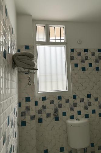 a bathroom with a toilet and a window at Hotel Siddhartha Gautama in Patna