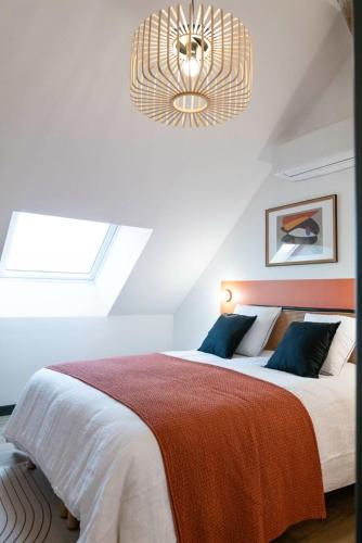 a bedroom with a large bed and a chandelier at L'Escapade d'Acquigny, Piscine, Foot Five, Salle de sport, BabyFoot in Acquigny