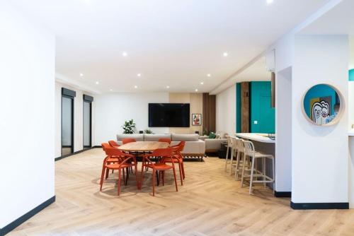 a dining room and living room with a table and chairs at L'Escapade d'Acquigny, Piscine, Foot Five, Salle de sport, BabyFoot in Acquigny