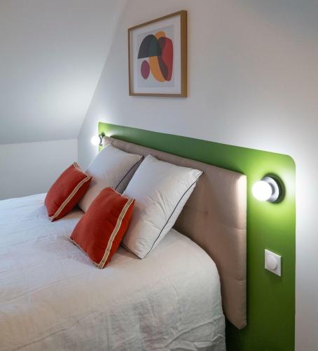 a bedroom with a green and white bed with pillows at L'Escapade d'Acquigny, Piscine, Foot Five, Salle de sport, BabyFoot in Acquigny