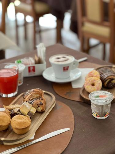 a table with a breakfast of pastries and a cup of coffee at Il Grifo Hotel e Bisteccheria Toscana in Montepulciano