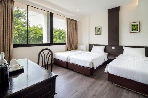 a hotel room with two beds and two windows at The Quay Hotel Little India at Broadway in Singapore