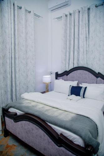 a bedroom with a large bed with white sheets at Stand-alone- 2BR house in Dodoma in Dodoma