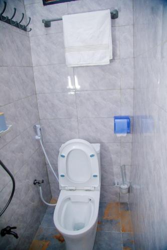 a bathroom with a toilet and a towel on the wall at Stand-alone- 2BR house in Dodoma in Dodoma