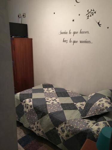 a bedroom with a bed with a checkered blanket at Hostal La Balsá in La Alberca