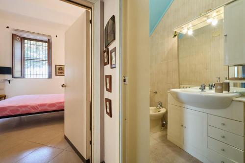a bathroom with a sink and a toilet and a bed at Casa Di Rosella in Gavorrano