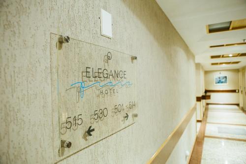 a hallway in a building with a sign on the wall at Elegance Praia Hotel in Rio de Janeiro
