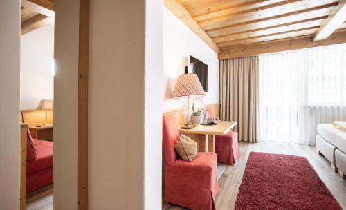a living room with red chairs and a table at Hotel Hubertus in Sölden