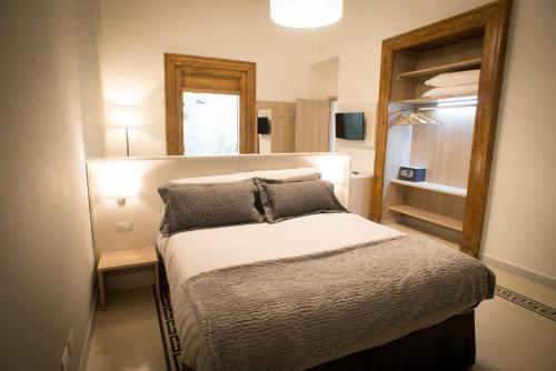 a small bedroom with a bed and a mirror at B&B Napolimilionaria Foria 242 in Naples