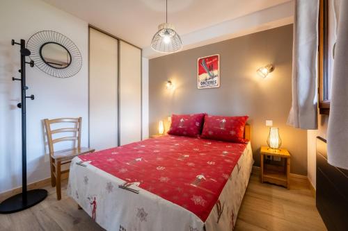a bedroom with a bed with red pillows and a chair at A203- Appartement 2 pieces cabine 6 personnes in Orcières