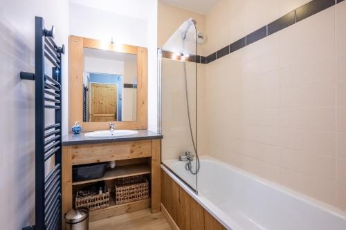 a bathroom with a tub and a sink and a mirror at A203- Appartement 2 pieces cabine 6 personnes in Orcières
