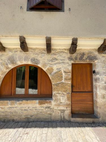 a building with a wooden door and a window at Studio La belle étape in Bretenoux