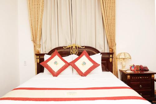 a bedroom with a bed with red pillows on it at New Pacific Hotel in Ho Chi Minh City