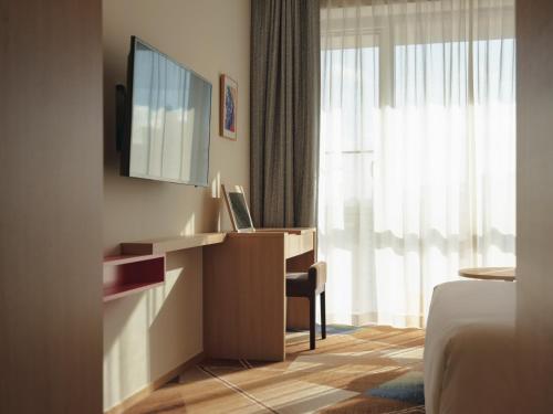 a hotel room with a desk and a television at Urbanstay Hotel Dongtan in Hwaseong