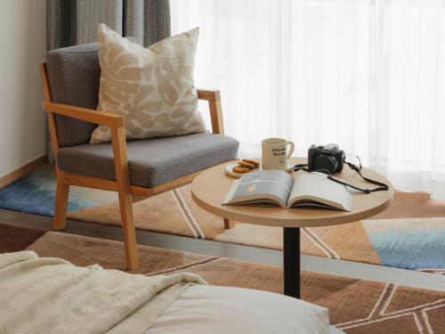 a living room with a chair and a table with a book at Urbanstay Hotel Dongtan in Hwaseong