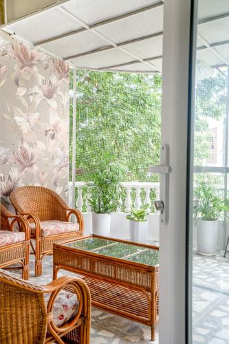 a patio with wicker chairs and a glass table at Girisadan Boutique Stay in Jaipur