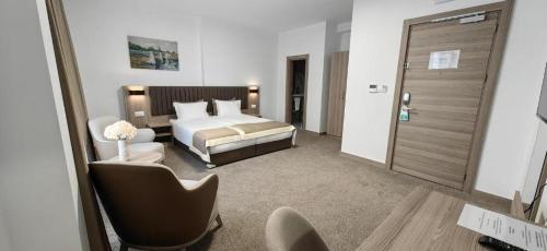 a hotel room with a bed and a chair at Evelin Deluxe House in Plovdiv