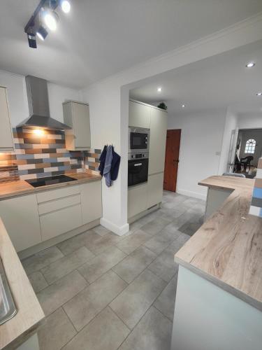 a large kitchen with white cabinets and appliances at Beachside Terrace in Dovercourt