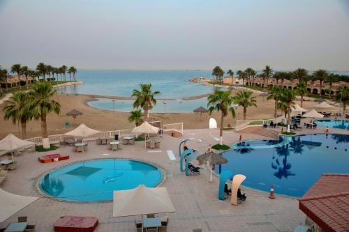 an aerial view of a resort with two pools and a beach at Mena Holiday Beach Resort Half Moon in Half Moon Bay