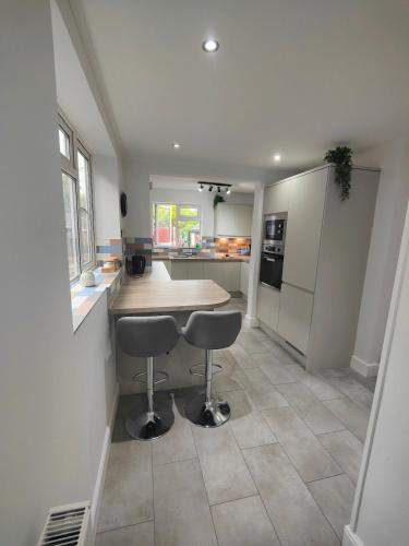 a kitchen with a table and two stools at Beachside Terrace in Dovercourt