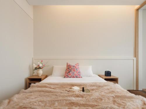 a bedroom with a large bed with two tables at Urbanstay Hotel Dongtan in Hwaseong