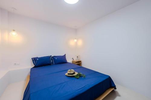 a bedroom with a blue bed with a hat on it at Lux Natura in Prinos
