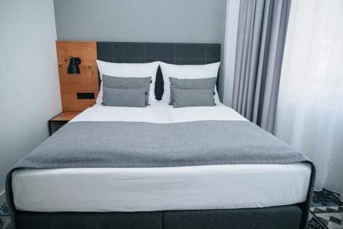 a bedroom with a large bed with pillows at Coffee Fellows Hotel Trier in Trier