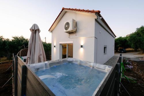 a hot tub in front of a house at Lux Natura in Prinos