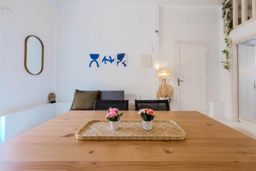 a large wooden table with two flowers on it at Lux Natura in Prinos