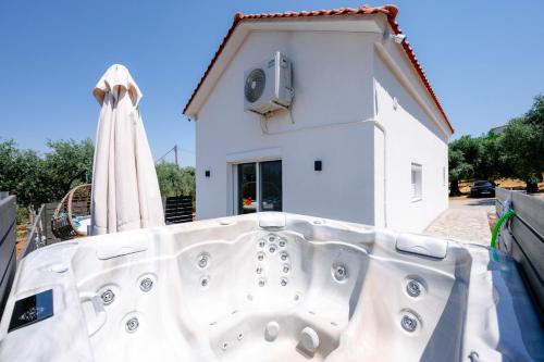 a bath tub in front of a white house at Lux Natura in Prinos