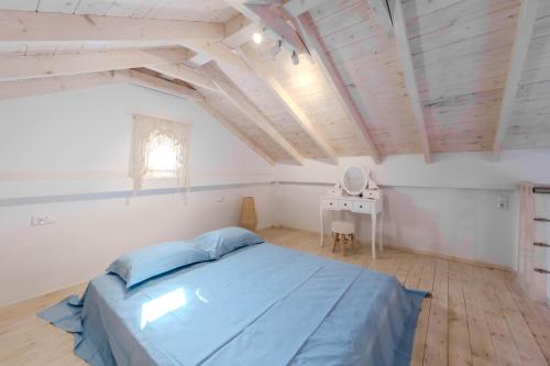 a bedroom with a blue bed and a table at Lux Natura in Prinos