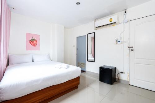 a white bedroom with a bed and a door at X Oh My Nap BTS Nana - โอ้ มาย แน็ป บีทีเอส นานา in Bangkok
