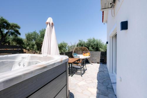 a bath tub sitting on a patio next to a table at Lux Natura in Prinos