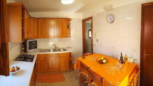 eine Küche mit einem orangefarbenen Tisch und einem Waschbecken in der Unterkunft Casa Vanni in Cefalú