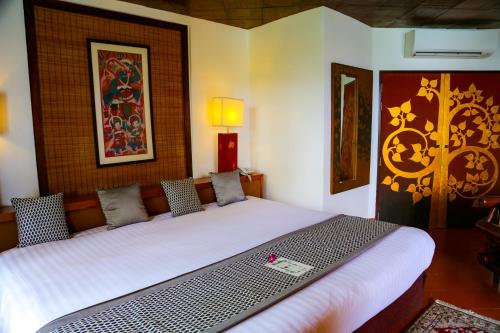 a bedroom with a large bed in a room at Mom Tri's Villa Royale - SHA Plus in Kata Beach
