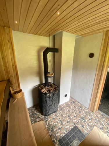 a small wood stove in a corner of a room at Metsanõmme saunamaja in Lümati
