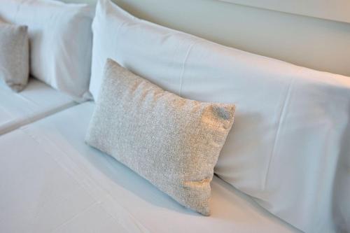 a white couch with white pillows on it at Hotel Ankaa - Adults Only in Porto Cristo